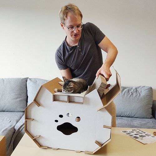 Falte eines der Ohren von Katzenhaus Astaire auf, entnimmt die alte Kratzmatte und lege die neue Kratzmatte ein.